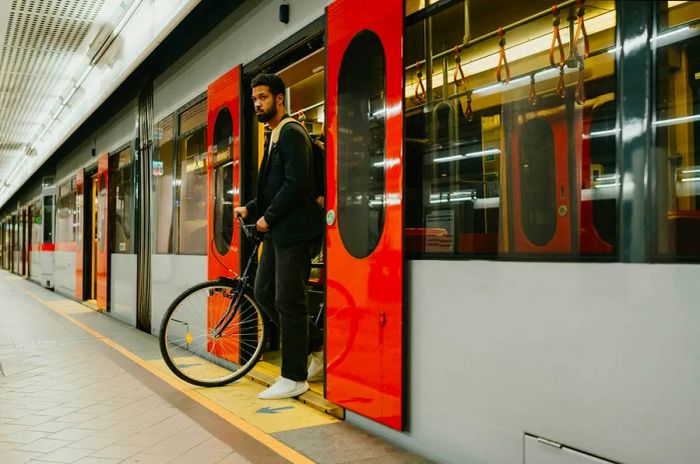 A man stepping off a train with his bicycle in Austria