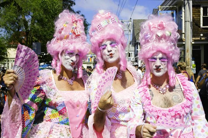 Drag queens in vibrant pink wigs participating in the annual Provincetown Carnival Parade in Provincetown, Massachusetts, USA