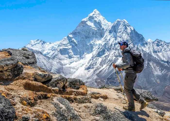 A hiker traversing a vast mountainous landscape