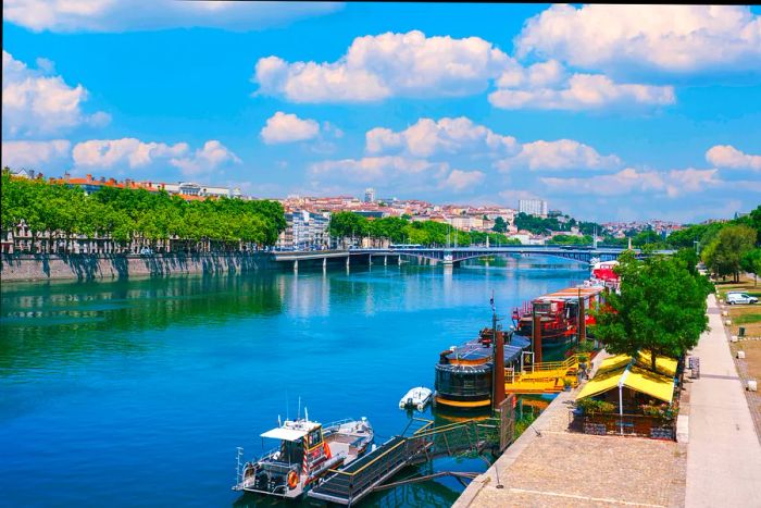 A bird's-eye view of the Rhône River in Lyon, France, on a sunny afternoon.