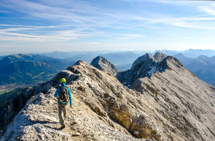 A hiker viewed from behind as they traverse a mountain