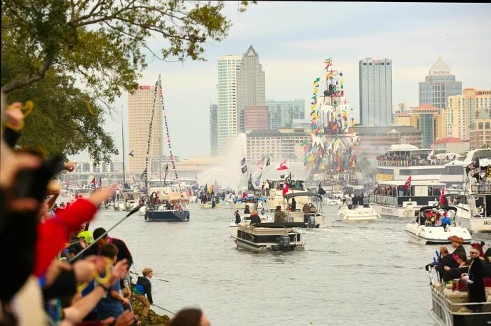 Enjoy people-watching from the shore as boats glide into Tampa Bay during the lively pirate-themed festival, Gasparilla.