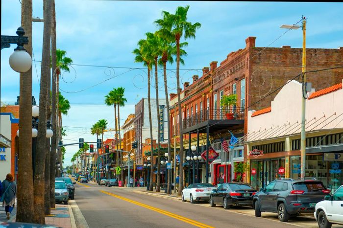 A charming historic street in Tampa's Ybor City, lined with classic brick buildings and swaying palm trees.