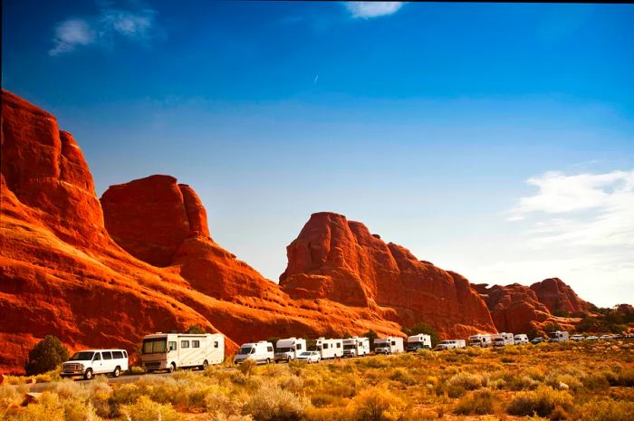 Busy RV campers enjoying their vacation in the stunning red rock scenery of Arches National Park near Moab, Utah.