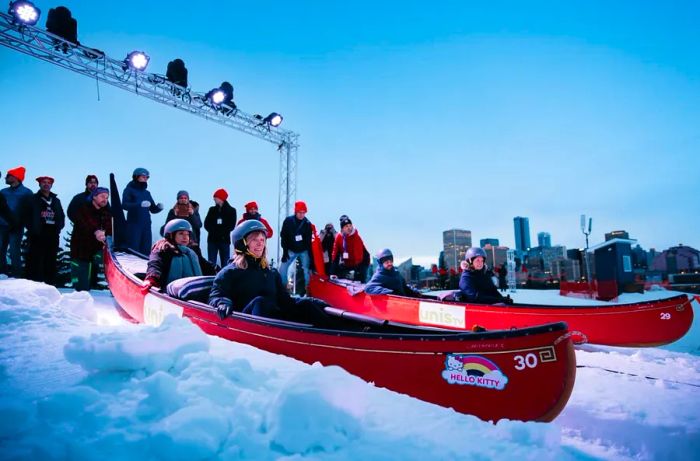 A group prepares to race down a snowy hill during the Flying Canoe Volant event.