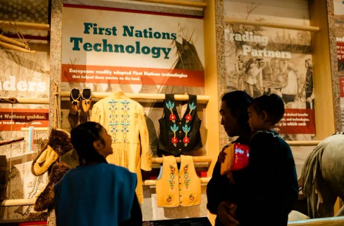 A family explores an exhibit on Indigenous technology at Fort Edmonton Park.