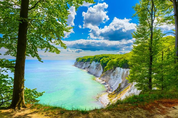 A breathtaking view of white cliffs descending to a sandy beach.