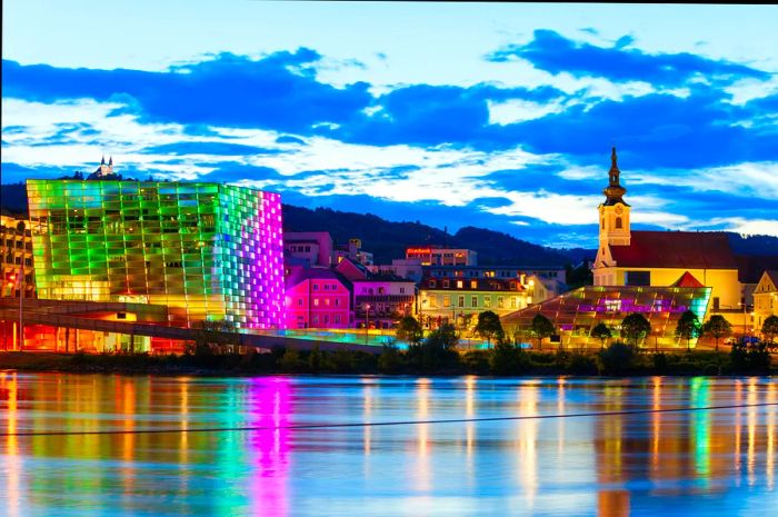 A museum building by the riverside illuminated at night