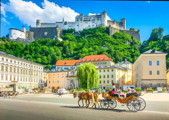 A horse-drawn carriage in the bustling central square, with a fortress-like structure towering above on a cliff.