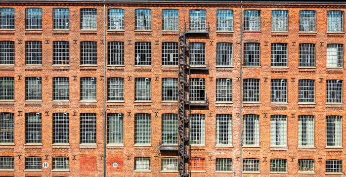 A brick factory building featuring an exterior spiral staircase