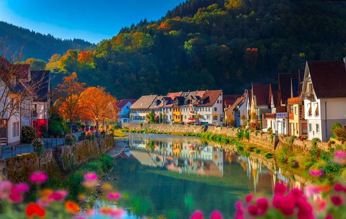 A river flows through a quaint town, lined with traditional houses.