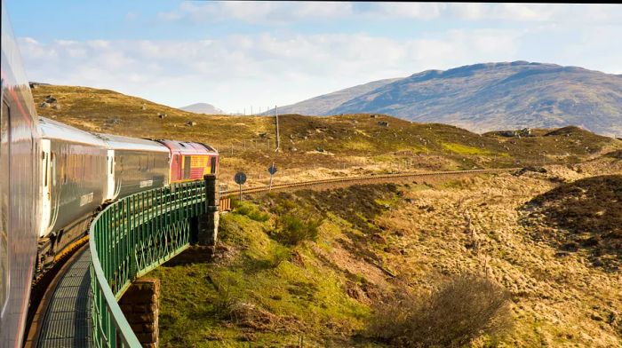 A train navigates a bend through picturesque countryside