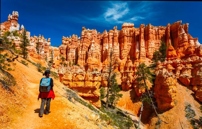 A female hiker traversing the Queens Garden Trail at Bryce Canyon National Park.