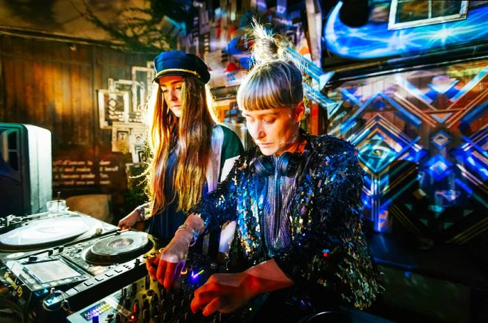 Two trendy DJs spinning tunes late into the night at a vibrant open-air nightclub in Berlin.