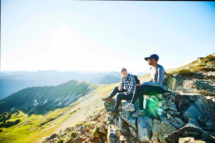 A cheerful couple enjoying a morning hike on rocky terrain in the mountains