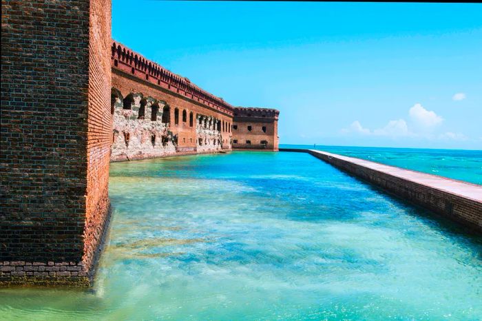 A brick fortress featuring a walkway at sea level