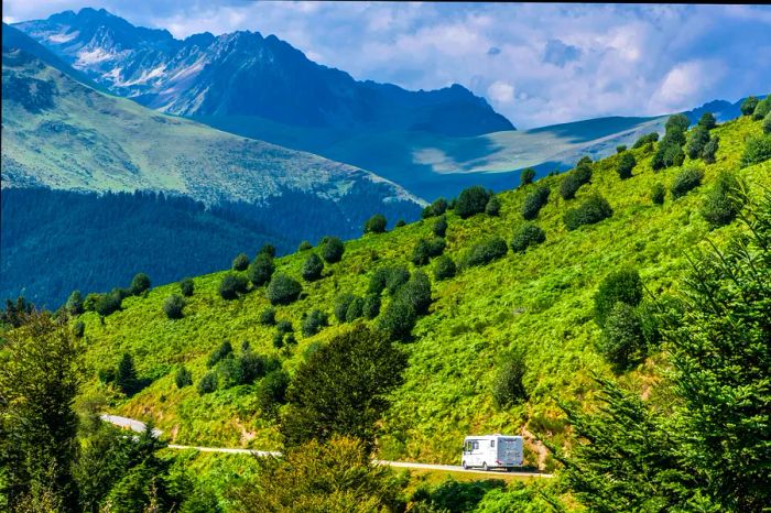 A camper traverses a road in the French Pyrenees.