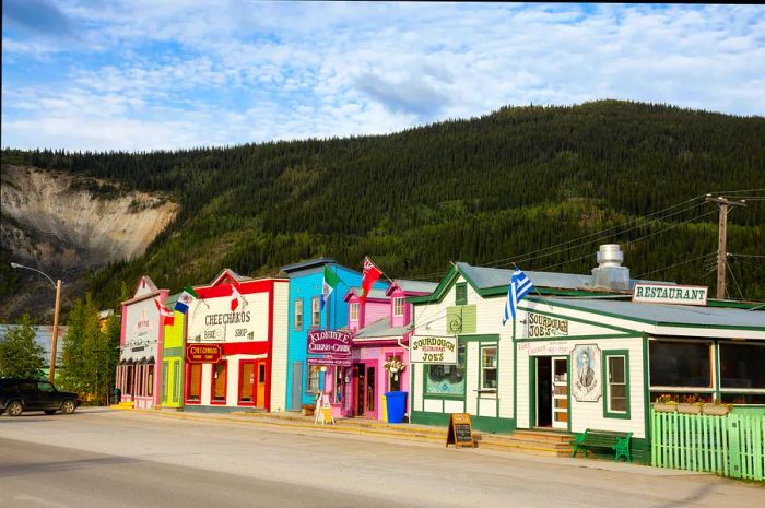 Vibrant historic buildings set against a mountain backdrop in Dawson City, Yukon, Canada