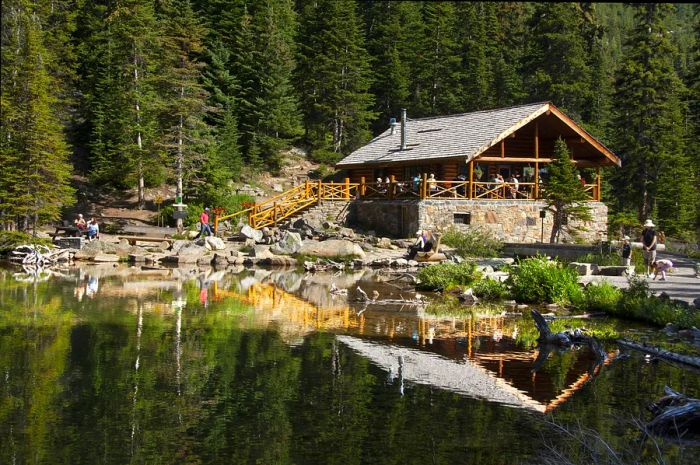 Visitors relax on the porch of Lake Agnes Tea House, located at Lake Louise, Alberta, Canada