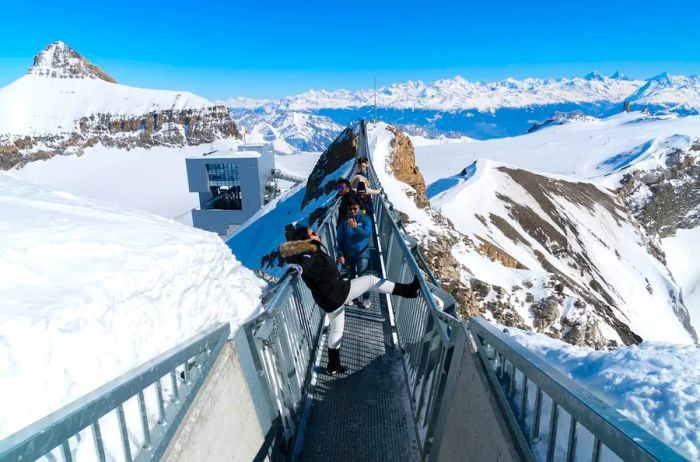 Tourists exploring the breathtaking Titlis Cliff Walk, a suspension bridge at Mount Titlis in Engelberg, Switzerland;