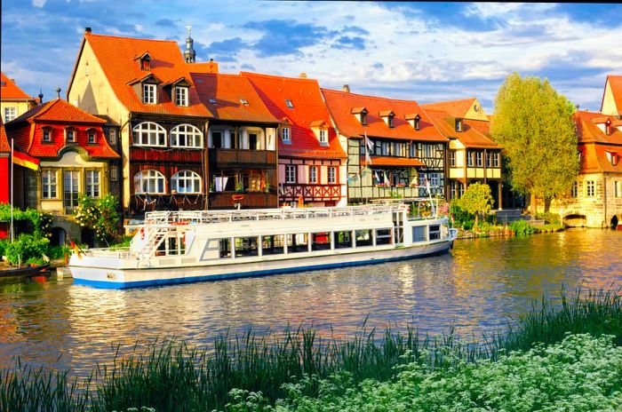 A sightseeing boat moored in front of historic fishing houses by a river