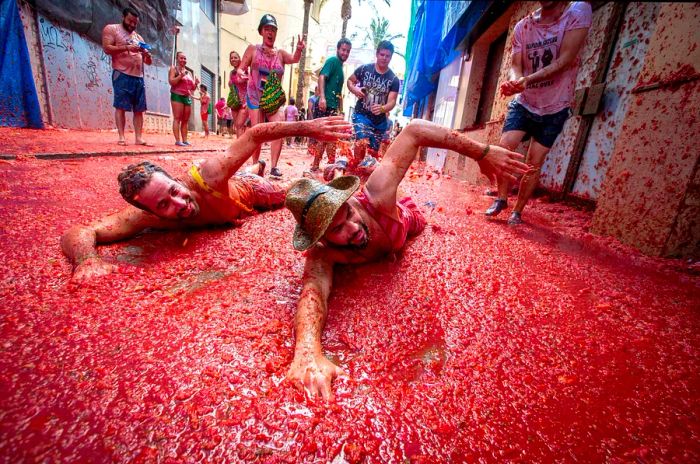 Participants joke about taking a dip in tomato pulp at the annual La Tomatina festival in Buñol, Spain