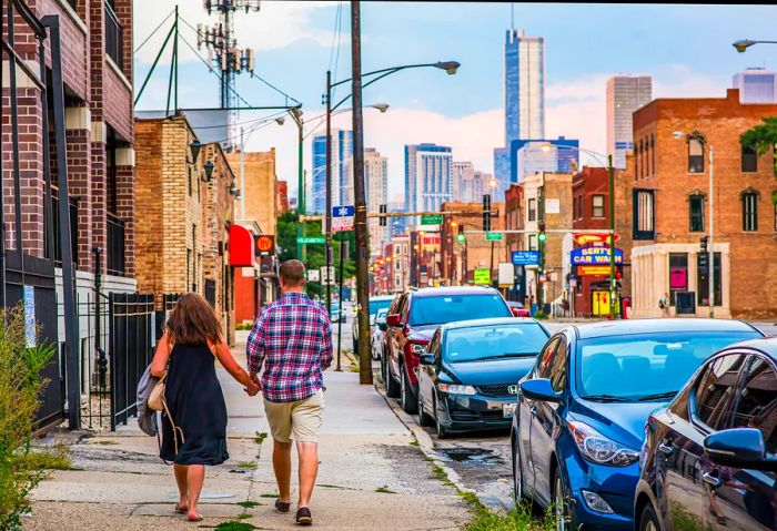 A young couple strolls toward a city skyline filled with skyscrapers