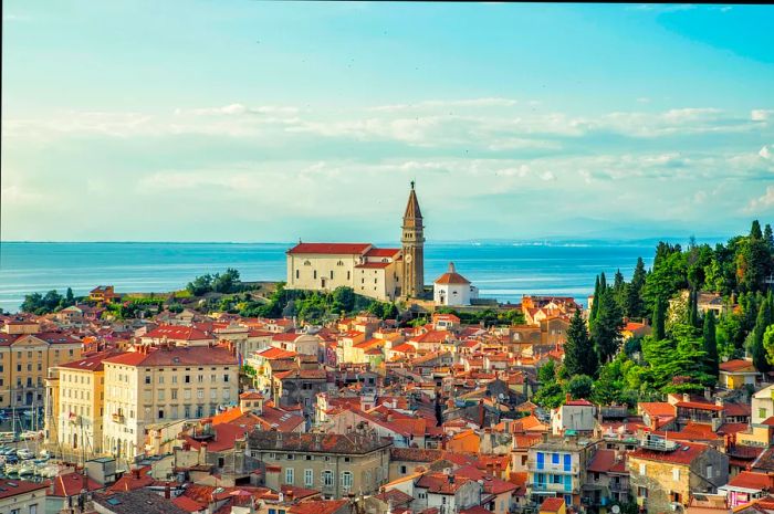 A picturesque medieval town perched on a hill by the sea, featuring a central clock tower