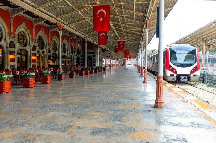 An elaborately decorated station platform adorned with Turkish flags hanging from the ceiling