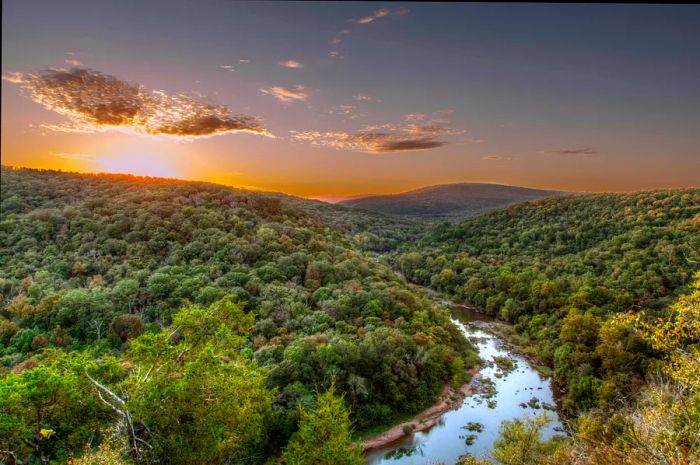 A river flows through a lush, wooded landscape