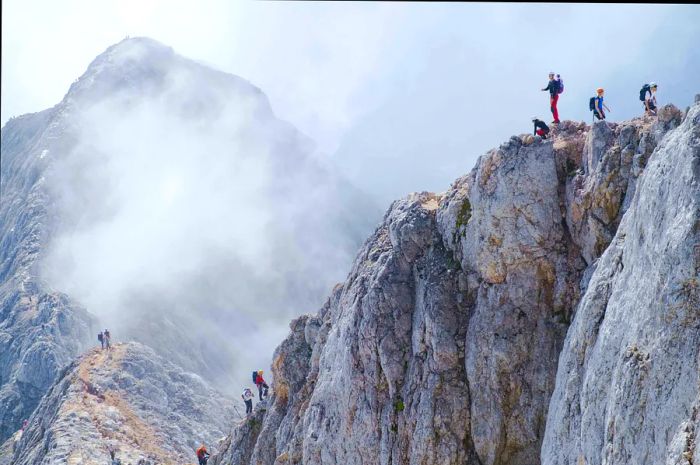 Climbers at the summit of a rugged mountain trail