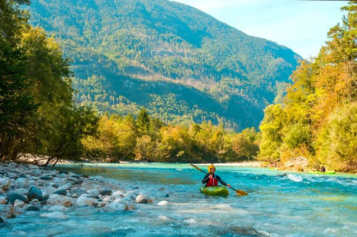 A woman kayaking on the Soča River in Bovec, Slovenia