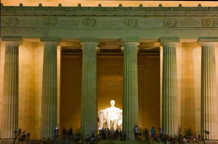 Tourists on the steps of the Lincoln Memorial at night, Washington, DC, USA