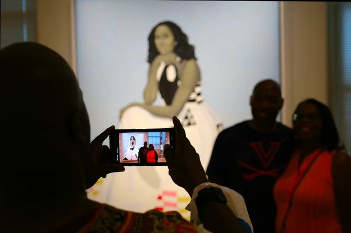 Visitors admire the portrait of First Lady Michelle Obama, painted by artist Amy Sherald, at the National Portrait Gallery in Washington, DC, USA.