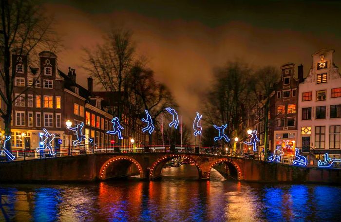 A bridge over a canal illuminated for the Amsterdam Light Festival