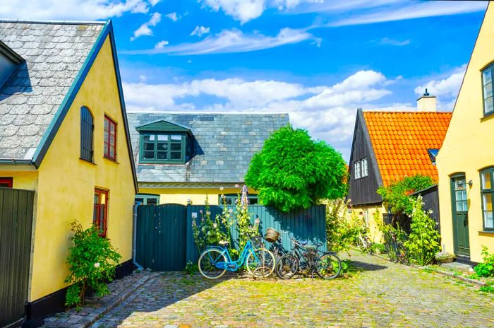 Charming streets adorned with beautiful, yellow historic houses showcase traditional Scandinavian architecture in Dragor, Denmark.