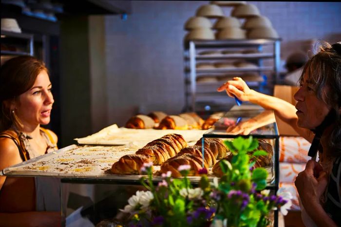 A woman chooses her treats at the counter of Juno Bakery in Østerbro, Copenhagen, Denmark