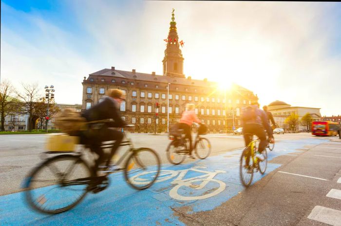 Cyclists riding in a designated blue bike lane in Copenhagen