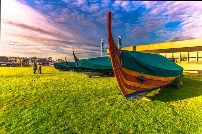 Replicas of Viking longships are displayed on the grass outside the museum.