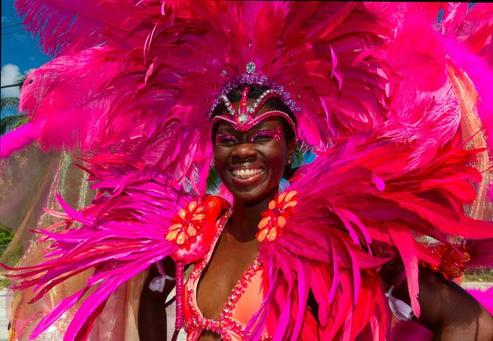 A woman adorned with a vibrant pink feathered headdress at a festival