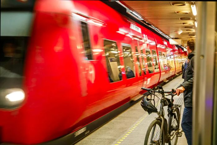 A red Copenhagen Metro train pulls into Nørreport station