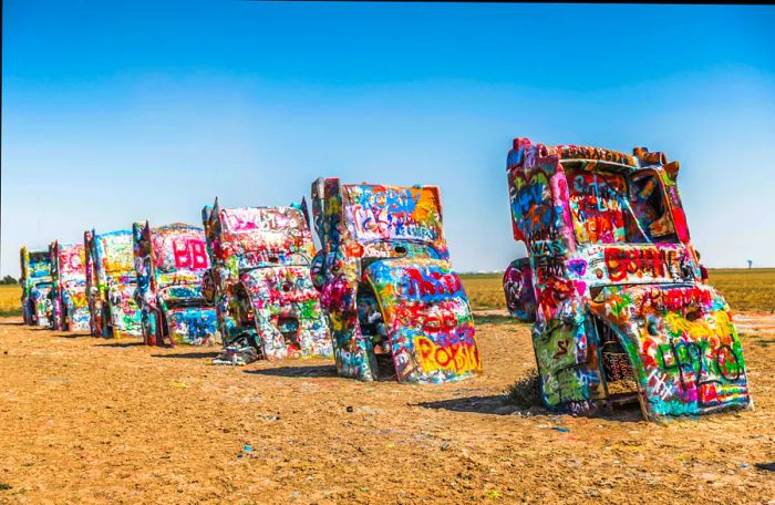 Colorfully painted Cadillacs are buried nose-down in the ground at Cadillac Ranch, Amarillo, Texas, USA