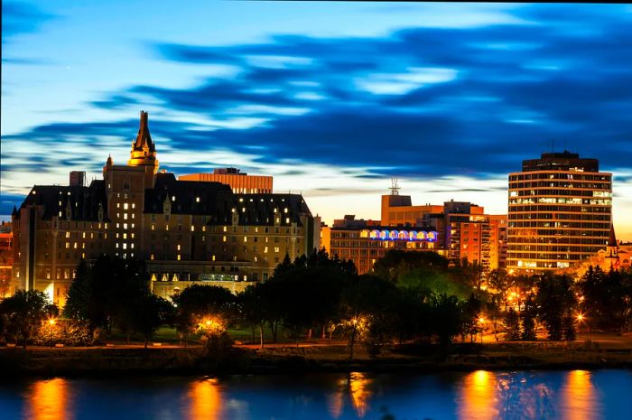 The night sky illuminates the riverside buildings after sunset.