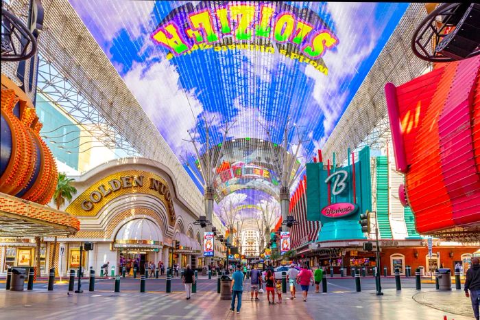 The vibrant activity of crowds fills the air during the day on the iconic Fremont Street in the heart of downtown Las Vegas, with its casinos, neon lights, and lively street entertainment.