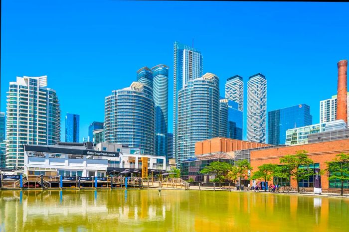 A picturesque waterway flanked by cultural buildings and towering skyscrapers.