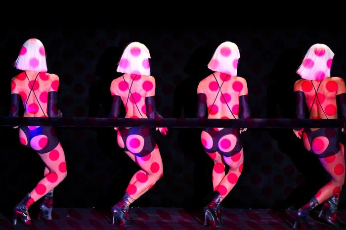 Dancers illuminated by polka dot lighting at the Crazy Horse cabaret, Paris, France