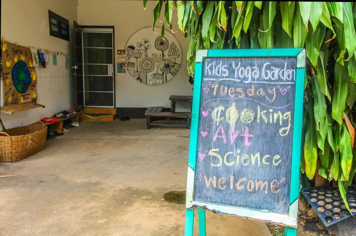 A standalone black chalkboard sign stands outside a building, reading: