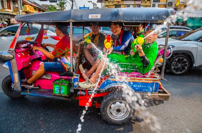 Tourists unleash water guns from a tuk-tuk on Khao San Road during the Songkran festival.