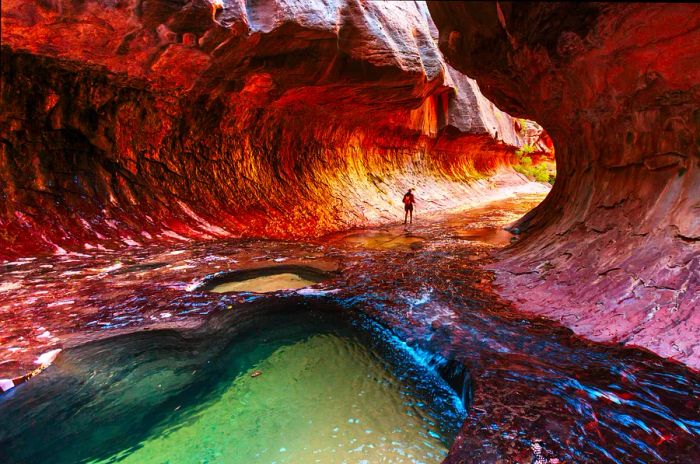 A hiker traverses the stunning Narrows gorge in Zion National Park.