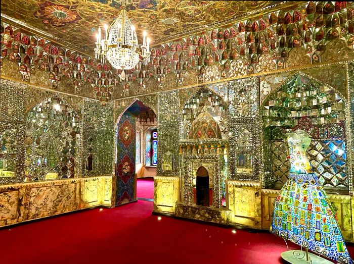 A room with red carpeting and kaleidoscopic mirrors adorning the walls.